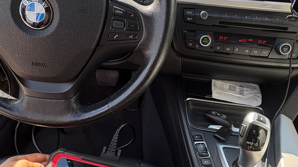 Mechanic using an OBD-II scanner at a car dashboard — mobile car diagnostics call-out
